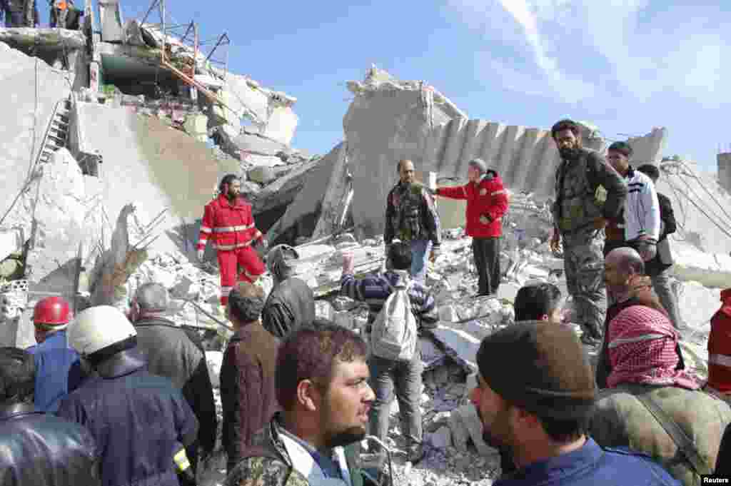 9일 차량 폭탄 테러가 발생한 시리아 알-카파트 시의 주택가에서 사람들이 건물 잔해 주변을 수색하고 있다.