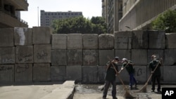 埃及扫街工人在几天示威抗议后清理开罗美国使馆附近地区