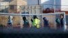 FILE - Teen migrants walk in line inside the Tornillo detention camp in Tornillo, Texas, Dec. 13, 2018.