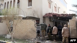 Pasukan keamanan Libya memeriksa lokasi ledakan bom di pintu masuk rumah Duta Besar Iran di Tripoli (22/2). 