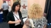 In this May 30, 2012 photo, Mi-Ran Park-Wong, of Macy's, speaks to a job applicant during a career expo sponsored by Jobs Direct USA in Orlando, Fla.