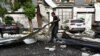 A man cleans up damage after a tornado hit the city of Suzhou in China's eastern Jiangsu province province on May 15, 2021. (Photo by STR / AFP) / China OUT
