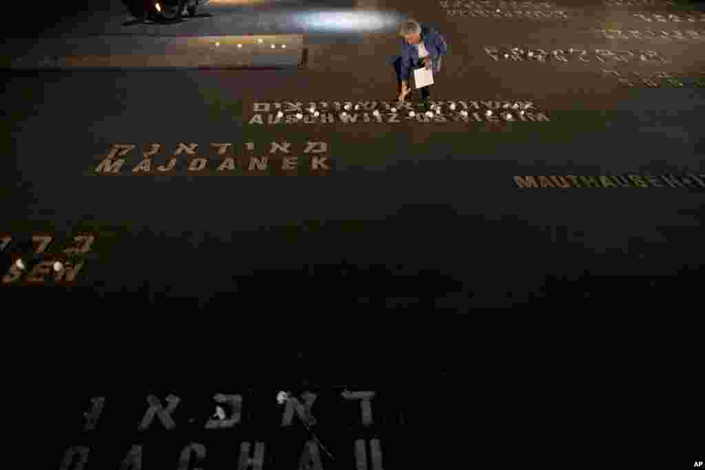 Seorang kerabat dari korban Holocaust meletakkan bunga dekat nama-nama korban kamp konsentrasi Holocaust di museum peringatan Holocaust di Yerusalem. 