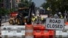 FILE - Construction workers repair a street near the White House in Washington, DC, on Aug. 10, 2021.