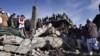 Local residents stand over the rubble of a damaged market caused by Saturday's bombing in Quetta, Pakistan on February 17, 2013. 