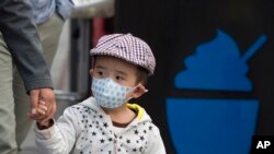 2016年10月14日，北京一名儿童戴口罩。北京市空气重污染应急指挥部办公室在下午将蓝色预警提升至黄色预警，北京城区PM2.5浓度接近每立方米350微克，达到6级严重污染