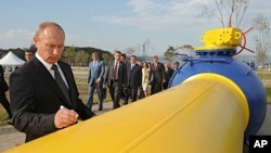 FILE - Vladimir Putin, who then was Russia's prime minister, autographs a natural gas pipeline in the Russian Far East city of Vladivostok during the pipeline's launch ceremony, Sept. 8, 2011. A contract allowing Russian gas to transit across Ukraine expired Dec. 31, 2024. 