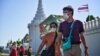 People walk with face masks outside the Grand Palace in Bangkok on January 27, 2020. - Thailand has detected eight Coronavirus cases so far -- three of whom are receiving treatment in hospital and five of whom have been discharged, according to a statemen