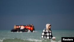 Seorang migran berjalan menuju perahu karet dalam upaya menyeberangi Selat Inggris untuk mencapai Inggris dari wilayah Wimereux, Prancis, pada 4 September 2024. (Foto: Reuters/Benoit Tessier)