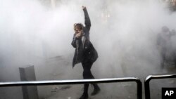 یک دختر دانشجو در اعتراضات روزهای اخیر در میان گاز اشک آور