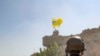 FILE - A U.S. soldier oversees members of the Syrian Democratic Forces as they demolish a Kurdish fighters' fortification and raise a Tal Abyad Military Council flag over the outpost as part of the "safe zone" near the Turkish border, Sept. 21, 2019.