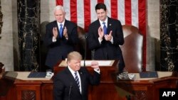 President Donald Trump, flanked by Vice President Mike Pence and House Speaker Paul Ryan of Wis., gestures on Capitol Hill in Washington, Feb. 28, 2017, before his address to a joint session of Congress. 
