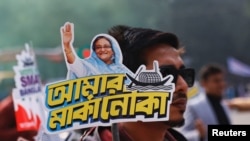 民众2024年1月4日手持支持现任总理谢赫·哈西娜（Sheikh Hasina）的宣传牌。（路透社）