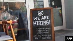 FILE - A 'We are hiring sign' in front of the Buya restaurant in Miami, Florida, March 5, 2021. 