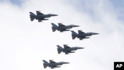 台湾空军F-16战机编队在一个庆祝双十节操演中飞越台北总统府上空。(2021年10月10日）