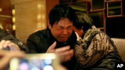 Jiang Hui (à g.) and Dai Shuqin, des parents de passagers disparus à bord du vol 370 de la Malaysian Airlines (AP)