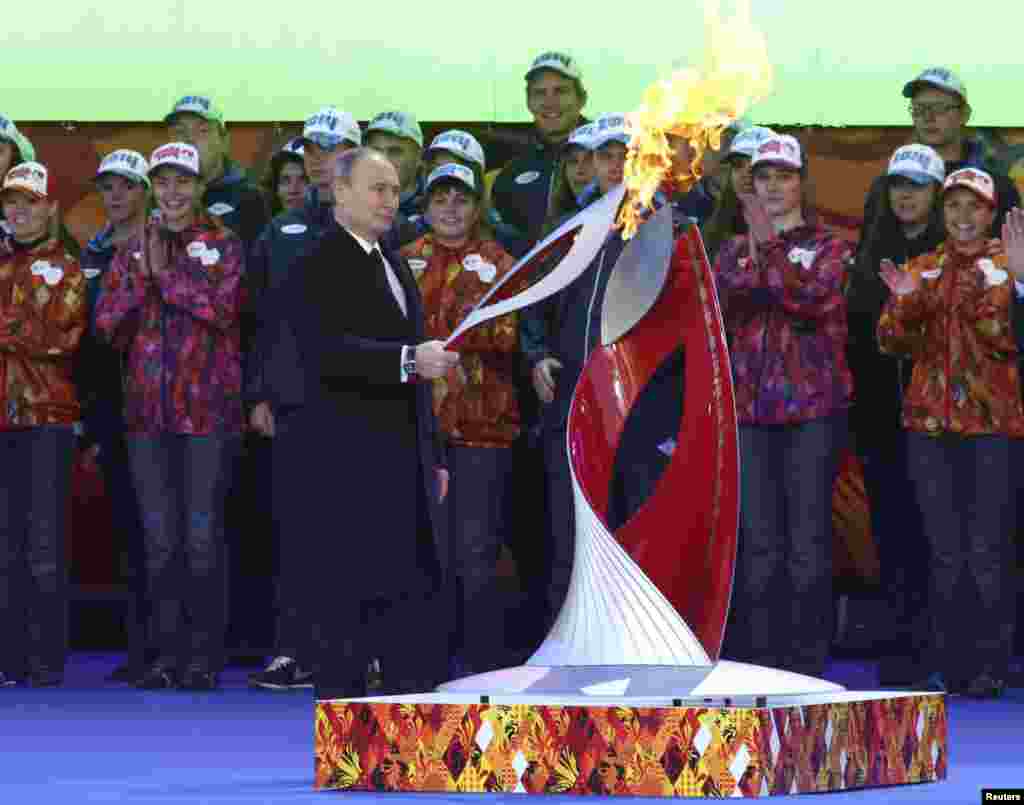 Presiden Rusia Vladimir Putin menyalakan obor Olimpiade Musim Dingin 2014 yang akan diarak dan dinyalakan pada pembukaan Olimpiade di kota Sochi, Rusia 7 Februari tahun depan. 