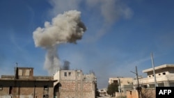 Smoke billows over the town of Saraqib in the eastern part of the Idlib province in northwestern Syria, following bombardment by Syrian government forces, Feb. 27, 2020. 