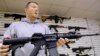 FILE - John Jackson, co-owner of Capitol City Arms Supply shows off an AR-15 assault rifle for sale at his business in Springfield, Illinois, Jan. 16, 2013.