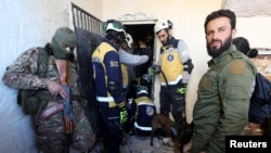 叙利亚民防组织成员（被称为“白头盔”）于2024年12月9日在赛德纳亚监狱，在反叛武装人员簇拥中搜寻在那里的囚徒。