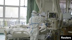 Wannan hoton da aka dauka a yankin Wuhan, na nuna yadda wani ma'aikacin kiwon lafiya yake kula da wani da ya kamu da cutar Coronavirus