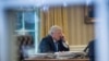 President Donald Trump speaks on the phone in the Oval Office at the White House in Washington, Jan. 28, 2017.