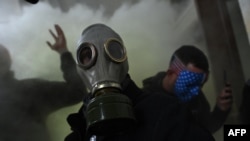 FILE - A supporter of U.S. President Donald Trump wears a gas mask as he protests after storming the U.S. Capitol, Jan. 6, 2021.