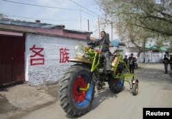一位维吾尔人在新疆玛纳斯县驾驶自制的摩托车