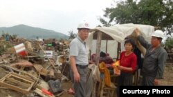 북한 적십자 소속 재난대응요원들이 지난 8월말 함경북도 회령시 주변 홍수 피해 지역에서 피해 규모를 파악하고 있다. 국제적십자가 20일 공개한 북한 수해 보고서에 들어있는 사진이다.