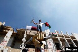 A Libyan rebel fighter takes a souvenir photograph as they make a final push to flush out pro-Gadhafi forces from the Bab al Aziziya compound in Tripoli, August 24, 2011.