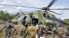 Ugandan soldiers, who are tracking down Lord's Resistance Army (LRA) fugitive leaders, load supplies off a military helicopter in a forest bordering Central African Republic, South Sudan and Democratic Republic of Congo, near river Chinko, April 18, 2012.