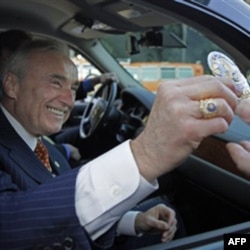 Los Angeles Police Chief William Bratton ceremonially hands in his badge as he prepares to leave the job in October 2009