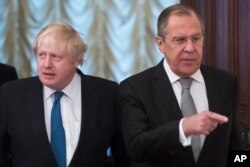 Russian Foreign Minister Sergey Lavrov (R) and British Foreign Secretary Boris Johnson enter a hall for their talks in Moscow, Russia, Dec. 22, 2017.
