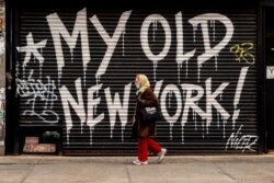 A person walks by a closed business in New York City, April 16, 2020. New York State Governor Andrew Cuomo announced during his daily COVID-19 briefing that the "New York State on PAUSE" order will be extended until May 15.