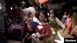 A member of Mexico's National Guard escort migrants, part of a caravan travelling to the U.S., near the border between Guatemala and Mexico, in Ciudad Hidalgo, Mexico, Jan. 20, 2020. 