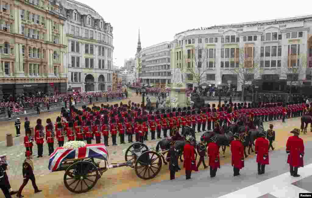 Peti mantan Perdana Menteri Inggris Margaret Thatcher, dibungkus bendera Inggris Union Flag, dibawa dalam sebuah kereta meriam yang ditarik oleh Pasukan Artileri Kerajaan dalam prosesi pemakaman di London, 17 April 2013. Thatcher, perdana menteri dari Partai Konservatif selama 1979 dan 1990, meninggal pada 8 April dalam usia 87.