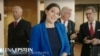 Michigan Republican candidate Lena Epstein against a backdrop of skeptical men in a screenshot from a campaign television ad.