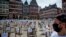 A man with a face mask watches empty chairs with names of bars and restaurants on the Roemerberg square in Frankfurt, Germany, April 24, 2020. Because of the coronavirus, all bars and restaurants in Germany are still closed. 