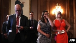 6月20日，桑迪胡克小学被杀害的校长道恩·霍斯普兰德女儿艾瑞卡·斯梅吉尔斯基（右二）在华盛顿国会聆听有关枪支管控的新闻发布会时抹下眼泪。