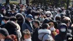 People line up to buy face masks to protect themselves from the new coronavirus outside Nonghyup Hanaro Mart in Seoul, South Korea, Thursday, March 5, 2020. The number of infections of the COVID-19 disease spread around the globe. (AP Photo/Ahn…