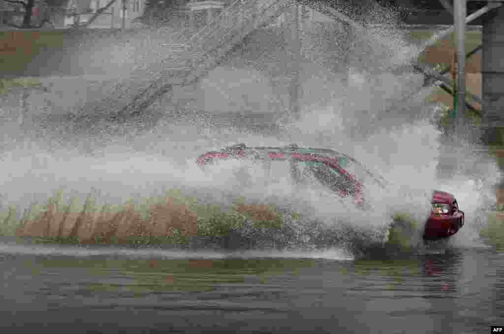 Seorang pengendara nekad melaju melalui jalanan yang digenangi banjir di kota Chicago, Illinois. 