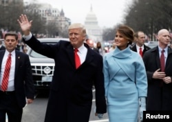 FILE - President Donald Trump waves as he walks with first lady Melania Trump and son Barron during the inauguration parade on Pennsylvania Avenue in Washington, Jan. 20, 2017.