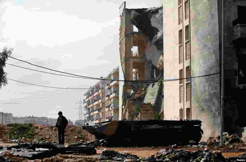 17일 시리아 알레포시에서 폭격으로 파괴된 차량 주변에 서 있는 어린이.