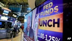 A television screen on the floor of the New York Stock Exchange shows the rate decision of the Federal Reserve, July 26, 2017. The Federal Reserve is keeping its benchmark interest rate unchanged at a time of low inflation, which remains persistently below the Fed's target level.