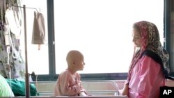 Parsa Amini, a 5-year-old boy suffering from eye cancer, speaks with his mother at Mahak Center's Hospital, in Tehran, Iran, June 19, 2019.