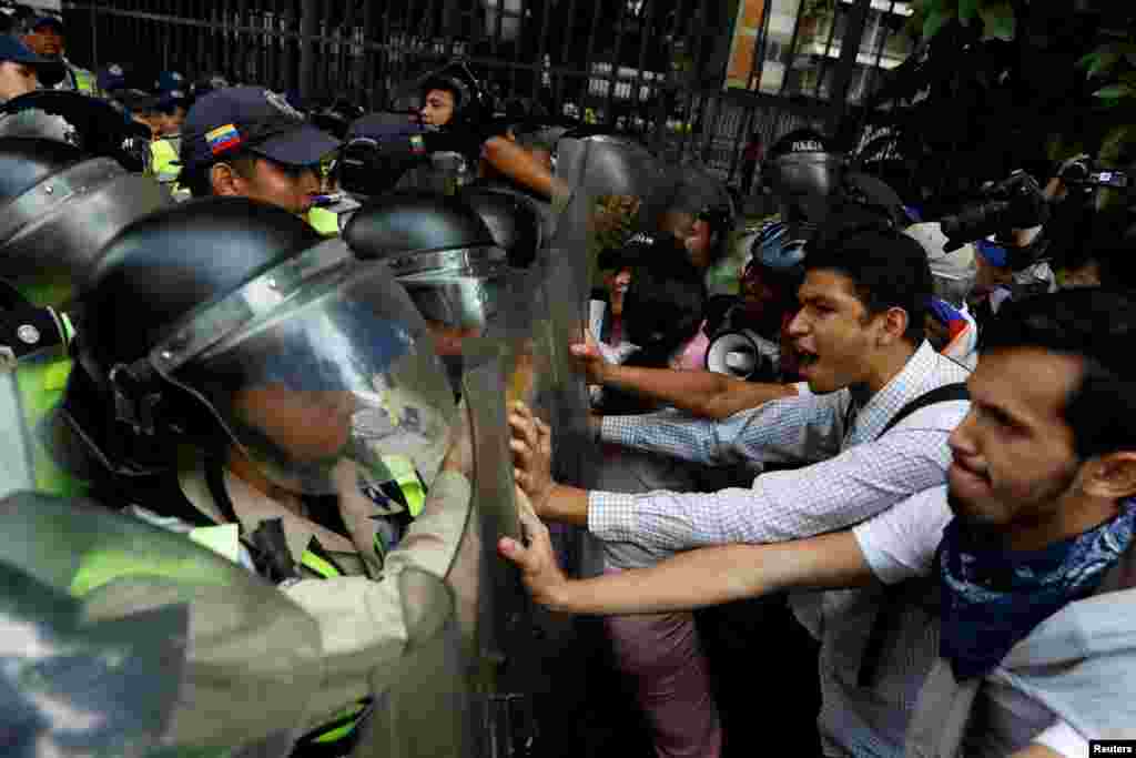 Opposition supporters confront riot security forces while rallying against President Nicolas Maduro in Caracas, Venezuela.