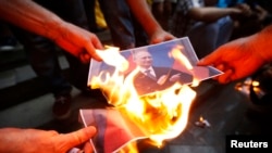 Para pengunjuk rasa membakar potret Presiden Rusia Vladimir Putin dalam sebuah unjuk rasa mendukung Ukraina di Tbilisi, Georgia. 29/8/2014. 