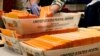 FILE - Election officials sort absentee and early voting ballots for counting inside Boston City Hall in Boston, Nov. 2, 2020.