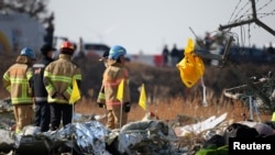 Спасатели разбирают обломки самолета, который разбился после взлёта в международном аэропорту Муан, Южная Корея, 29 декабря 2024 г.