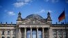 FILE - A German flag flutters in front of the Reichstag building in Berlin, Germany, Sept. 6, 2020. The inscription on the building reads "[Dedicated] to the German people."
